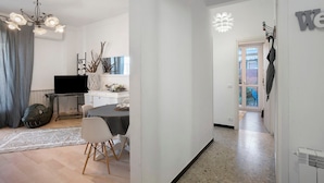 A modern living room with a dining area, a TV, and a chandelier. - Apartment 'Alassio Mare E Non Solo 2' with Sea View, Wi-Fi and Air Conditioning (Alassio)