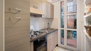A modern kitchen with a gas stove, stainless steel sink, and wooden cabinets. - Apartment 'Alassio Mare E Non Solo 2' with Sea View, Wi-Fi and Air Conditioning (Alassio)