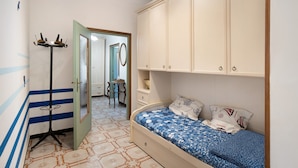 A bedroom with a bed, wardrobe, and a standing lamp. - Apartment 'Alassio Mare E Non Solo' with Sea View, Wi-Fi and Air Conditioning (Alassio)