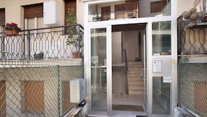 A building entrance with a glass door, a metal fence, and a sign indicating 'ST&A'. - Apartment 'Alassio Mare E Non Solo' with Sea View, Wi-Fi and Air Conditioning (Alassio)