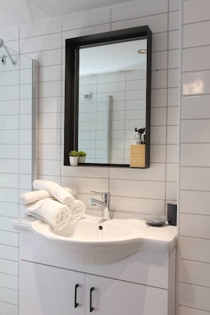 A bathroom with a white sink, a mirror, and a towel rack. - Fair Grounds STU Univ. by Sea N' Rent (Tel Aviv)