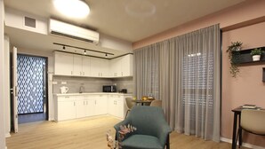 Ein modernes Wohnzimmer mit Essbereich, einer Küche und einem großen Fenster mit Vorhängen.
