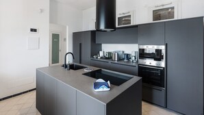 Una cocina moderna con una isla central, electrodomésticos integrados y un amplio ventanal sobre el fregadero.