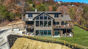 A modern two-story house with a large balcony, a garage, and a well-maintained lawn. - Ridgetop Retreat, Sleeps 11・Theater・Pool・Hot tub (Sevierville)