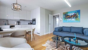 Un salon moderne avec un canapé, une table basse et un tableau accroché au mur.
