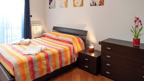 Ein Schlafzimmer mit Bett, Kommode und Nachttisch.