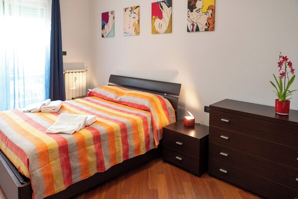 A bedroom with a bed, a dresser, and a nightstand.