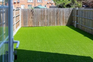 A fenced outdoor area with artificial green turf.