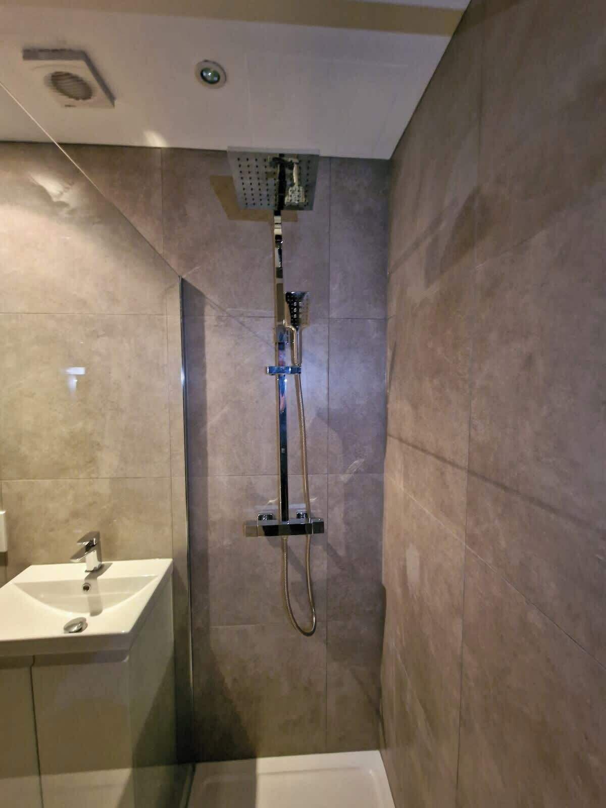 A bathroom with a shower, a sink, and a toilet.