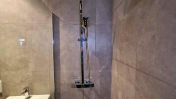 A bathroom with a shower, a sink, and a toilet.