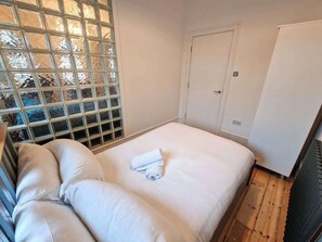 A room with a bed, a white door, and a radiator. - 2 Bed Northern Quarter Flat | City Centre (Manchester)