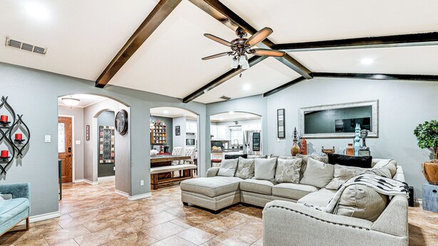 A spacious living room with a sectional sofa, a ceiling fan, and a kitchen in the background. - 3 Mi to Downtown Mcallen: Quiet Home w/ Pool (McAllen)