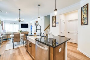 Une cuisine moderne dotée d’un îlot central, de meubles en bois et d’appareils électroménagers en acier inoxydable.