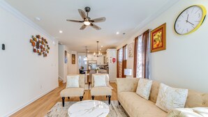 A spacious living room with a beige sofa, two armchairs, a coffee table, and a ceiling fan. - 12 Mi to Dtwn Richmond: Spacious Home w/ Deck! (Richmond)
