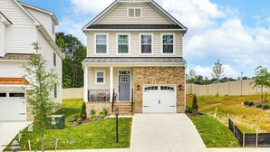 A two-story house with a front garage, a small porch, and a well-maintained lawn. - 12 Mi to Dtwn Richmond: Spacious Home w/ Deck! (Richmond)