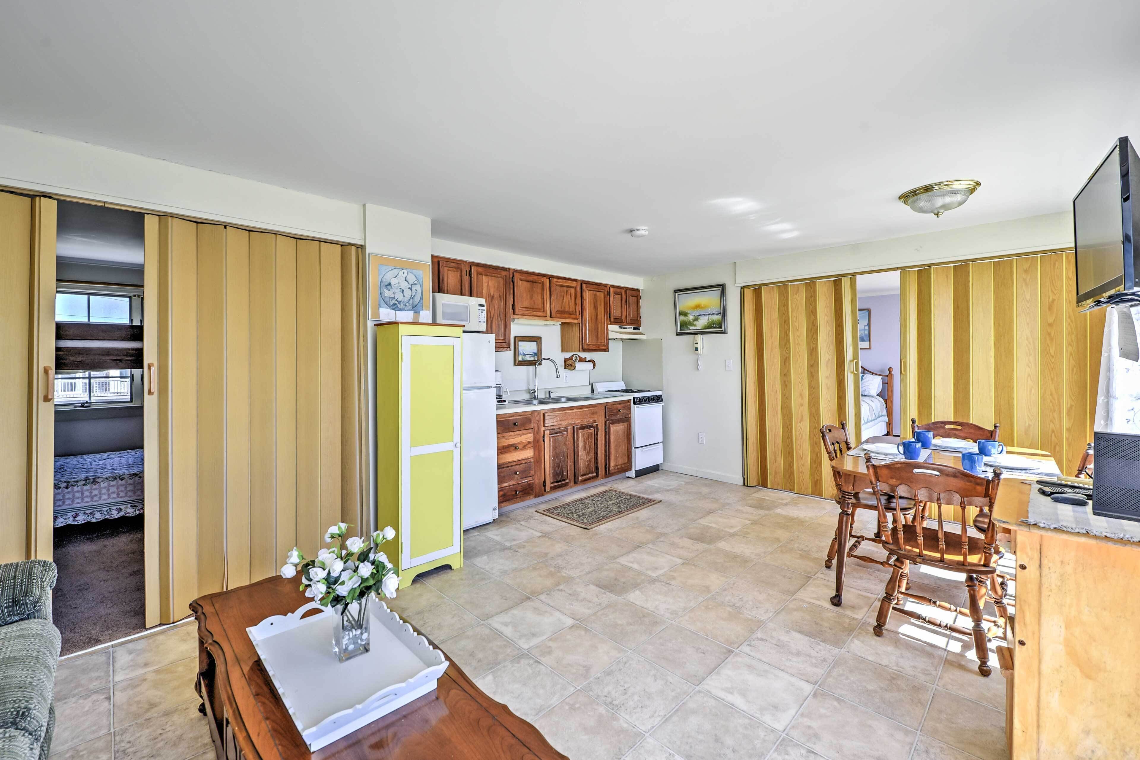 A compact living space with a kitchen, dining area, and a small bedroom.