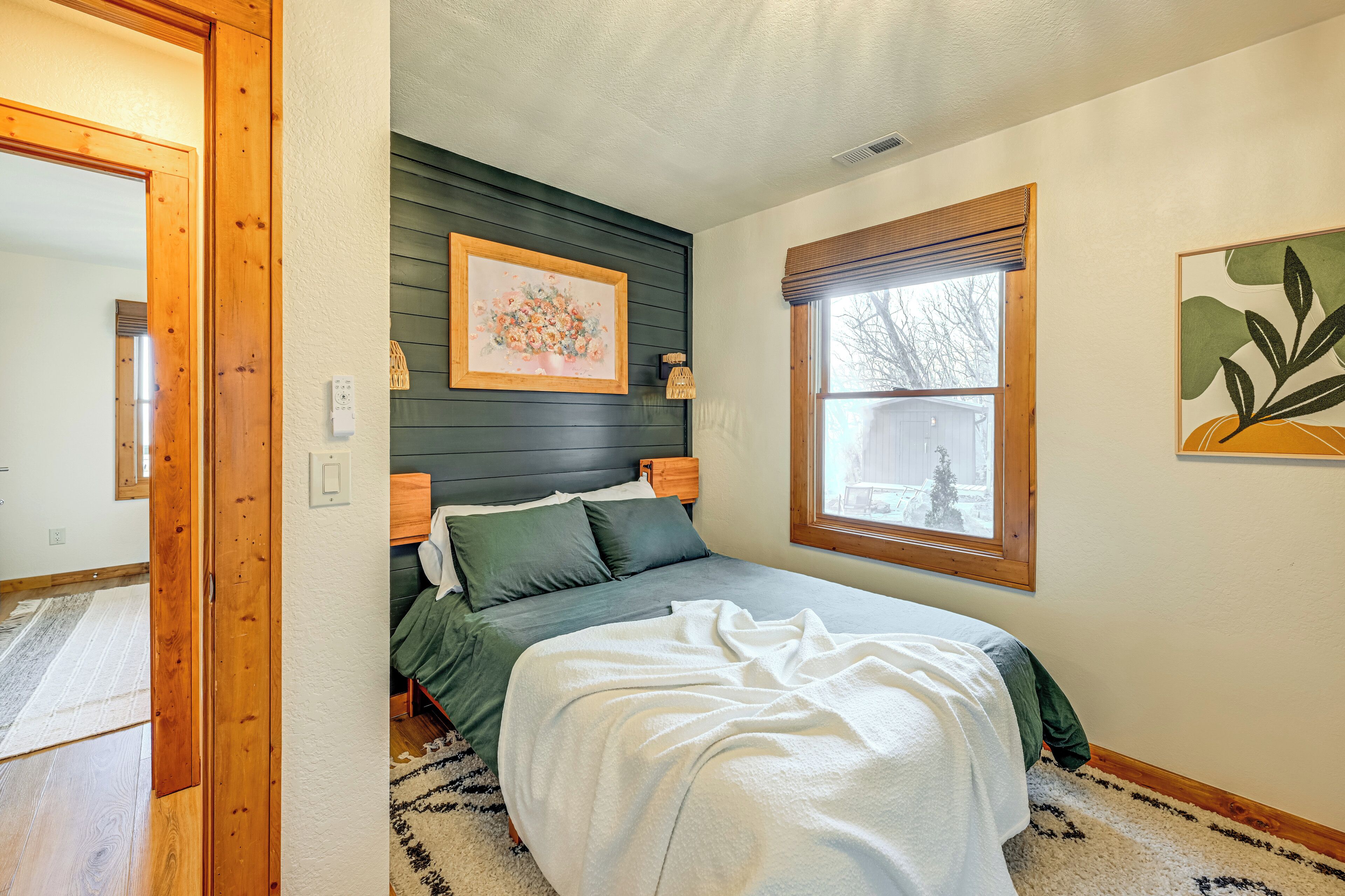 Ein Schlafzimmer mit einem Bett, einem Fenster und zwei Wandleuchten.