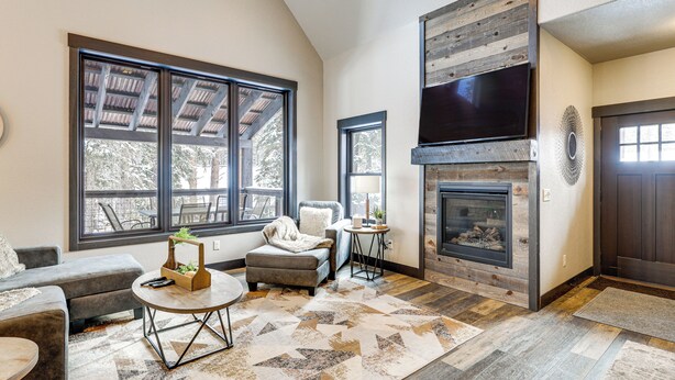 A living room with a fireplace, large windows, a sofa, and a coffee table. - Hot Tub & Trail Access: Black Hills, Rally Stay! (Lead)