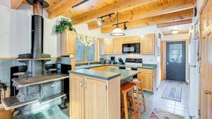 A kitchen with wooden cabinets, a central island, a stove, and a microwave.