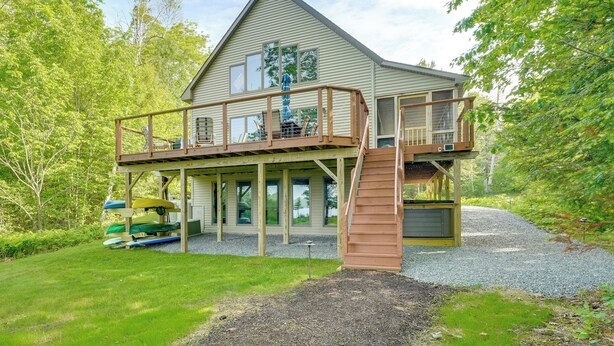 A two-story house with a deck, a staircase, and a covered porch.