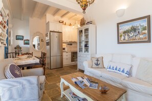 A compact living space with a dining area, kitchen, and seating area. - Villa 'Tinos Traditional Sea Side' with Sea View, Wi-Fi and Air Conditioning (Agios Romanos)