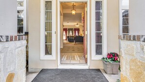 A house entrance with a door leading to a living room.