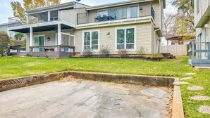 Une maison à deux étages dotée d’un patio couvert, d’une antenne parabolique et d’une cour clôturée.