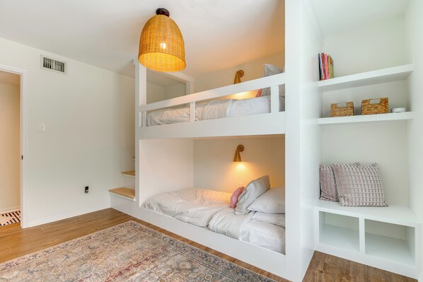 A multi-level bunk bed room with a patterned rug, white shelving, and a hanging light fixture. - Walk to Lake Conroe: Family-friendly Getaway! (Montgomery)