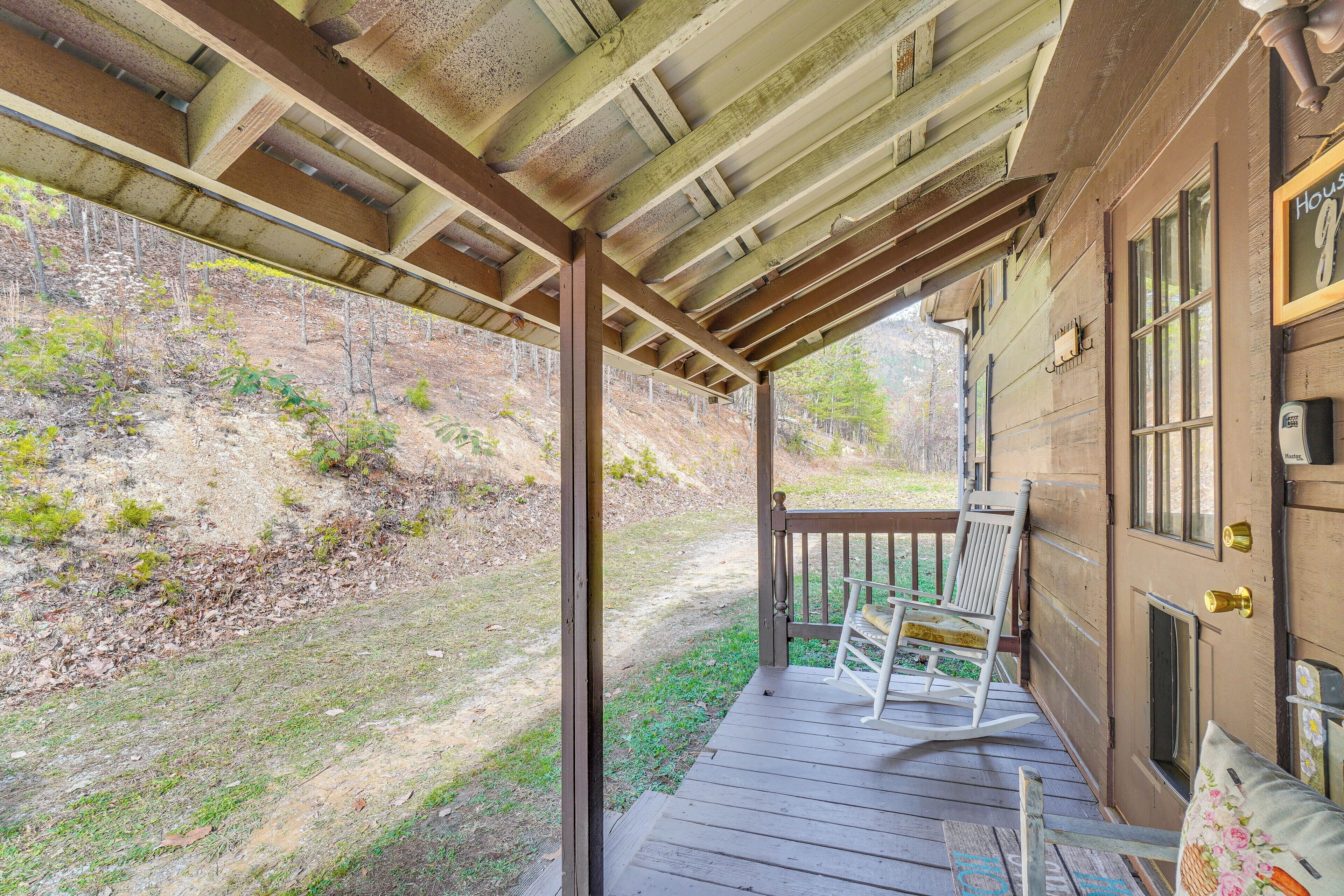 A wooden porch with a bench and a door with a brass knocker.