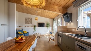 Eine moderne Küche mit Holzschränken, einem eingebauten Backofen und einem großen Fenster.