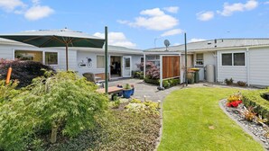 A residential property with a patio, outdoor seating, and a garden. - Hidden Gem (Hamilton)