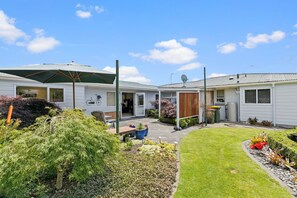 A residential property with a patio, outdoor seating, and a garden. - Hidden Gem (Hamilton)