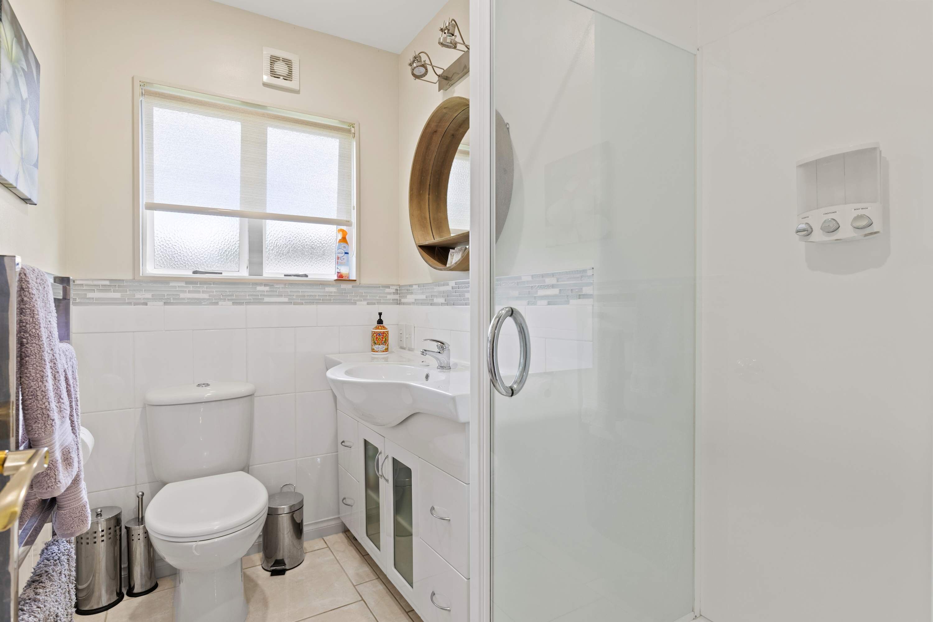 A modern bathroom with a toilet, sink, and shower.