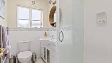 A modern bathroom with a toilet, sink, and shower.