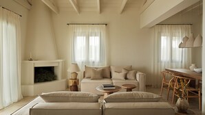 A spacious living room with a sofa set, a fireplace, and a dining area.