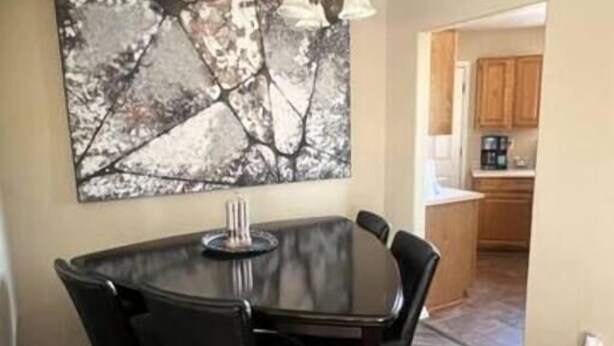 A dining area with a round table and chairs, a ceiling fan, and a kitchen in the background. - The Gentleman's Jack, Moovalya Keys Value (Parker)