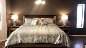 A bedroom with a large bed, two bedside lamps, a ceiling fan, and a window. - The Gentleman's Jack, Moovalya Keys Value (Parker)