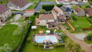 A residential property with a swimming pool, outdoor seating, and a well-maintained garden.