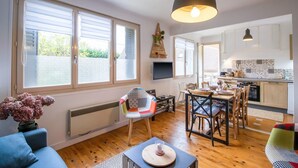 A modern interior with a dining area, kitchen, and large windows.