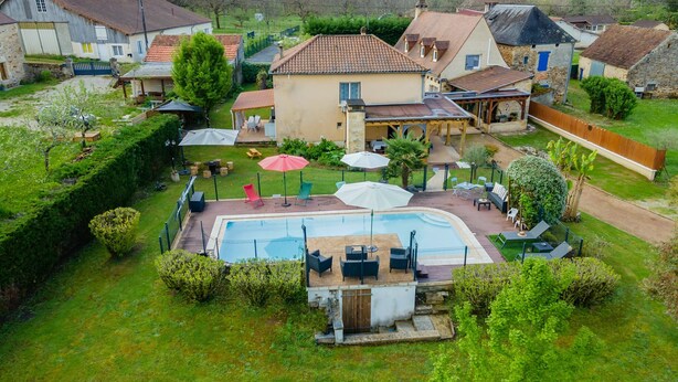 A residential property with a swimming pool, outdoor seating, and a garden.