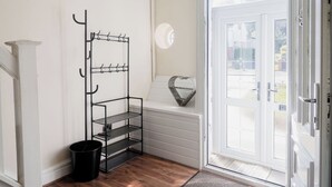 A white interior with a black metal shelf unit against the wall, a white door with glass panels, and a heart-shaped decoration on the door frame. - 6-bed House - Sleeps 13 - Families & Contractors (Dudley)
