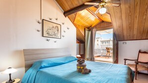 A bedroom with a bed, a nightstand, a chair, a window, and a ceiling fan. - Apartment 'Reale' with Private Terrace, Wi-Fi and Air Conditioning (Gravina di Catania)