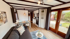 A compact living space with a sofa, dining table, and kitchenette.