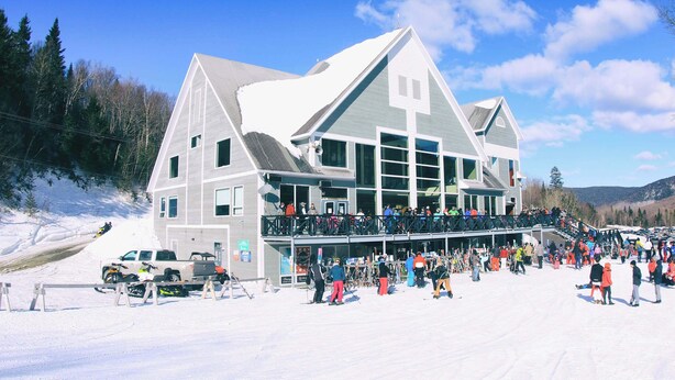 Un edificio grande con un balcón, rodeado de nieve.