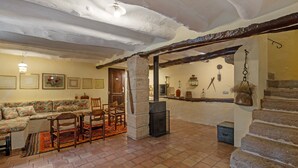 Um interior rústico com lareira de pedra, móveis de madeira e piso de azulejos.