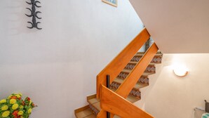 A staircase with wooden handrails and a light fixture on the wall.