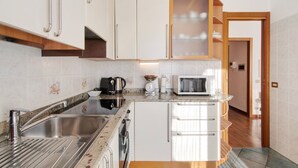 Una cocina moderna con electrodomésticos de acero inoxidable, horno empotrado y microondas.