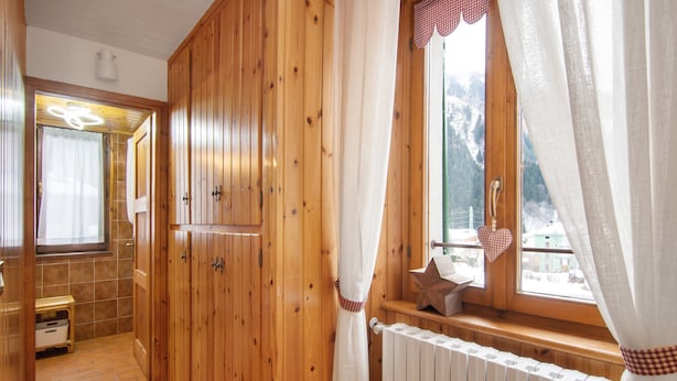 Ein Holzinnenraum mit Fenster, Heizkörper und kleinem Tisch.
