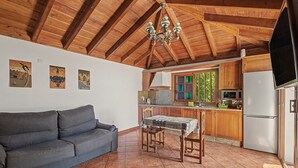 A cozy kitchen with wooden beams, a dining table, and a sofa. - 'Finca Verónica' with Sea View, Wi-Fi and Air Conditioning (Candelaria)