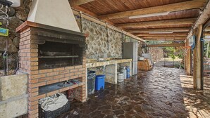 An outdoor kitchen area with a brick oven, stone flooring, and a rustic wooden ceiling. - 'Finca Verónica' with Sea View, Wi-Fi and Air Conditioning (Candelaria)